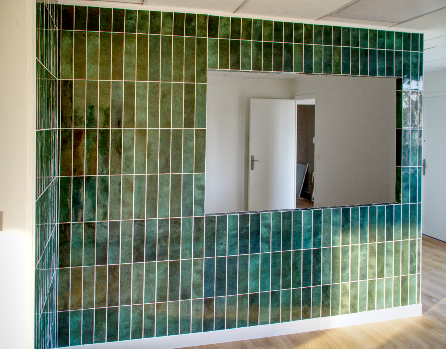 Mur intérieur en zelliges vert 5x30 avec finition en coupe 45° sans baguette, réalisé par CCJ Carrelage dans un studio de yoga après dépose de fenêtre.