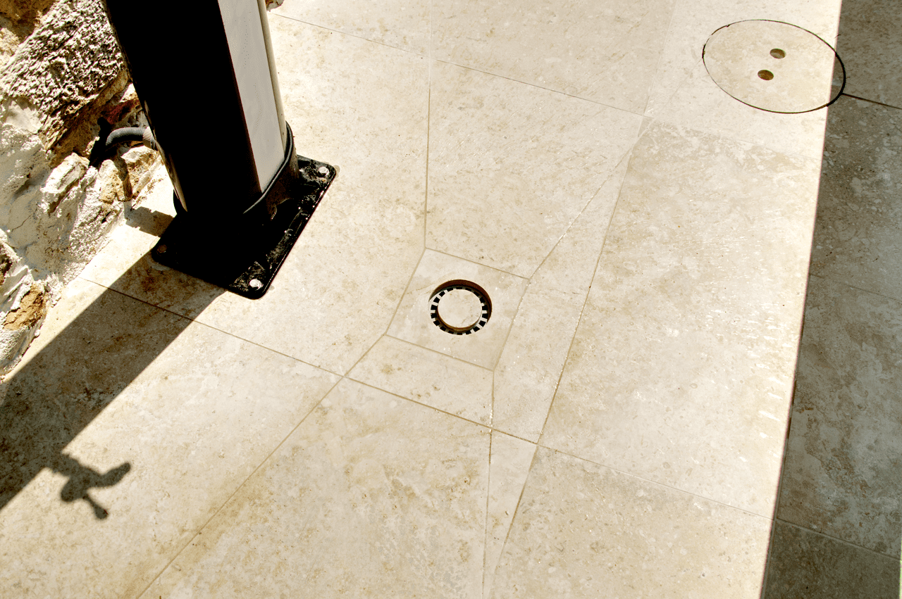 Détail d’un siphon de sol intégré au carrelage avec coupe précise, réalisé par CCJ Carrelage à Vendargues. Finition discrète et parfaitement alignée.